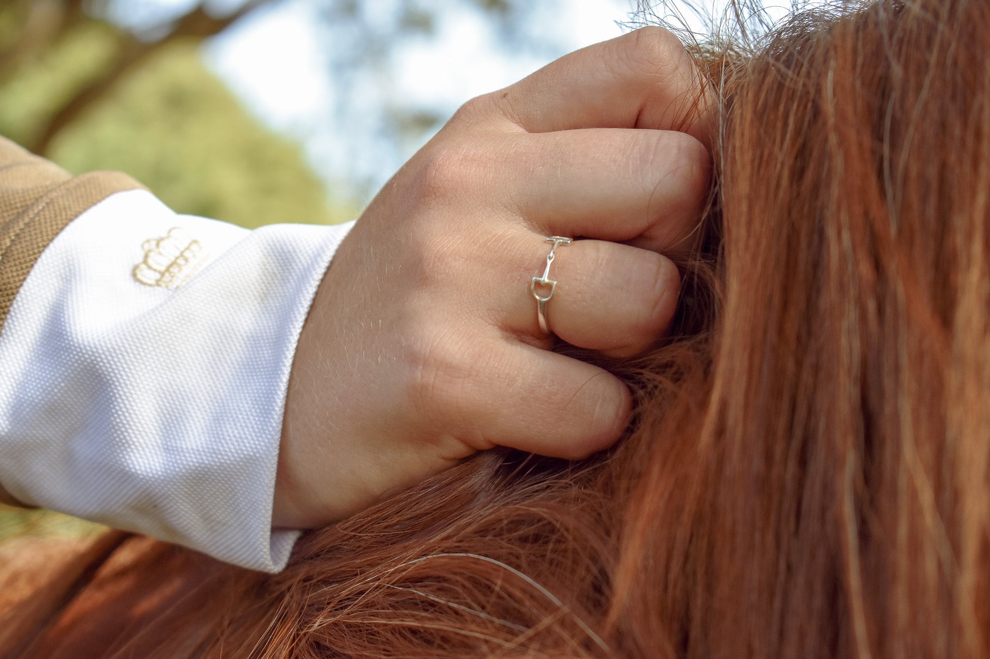 Rider holding horses mane with sterling silver bit ring in full focus