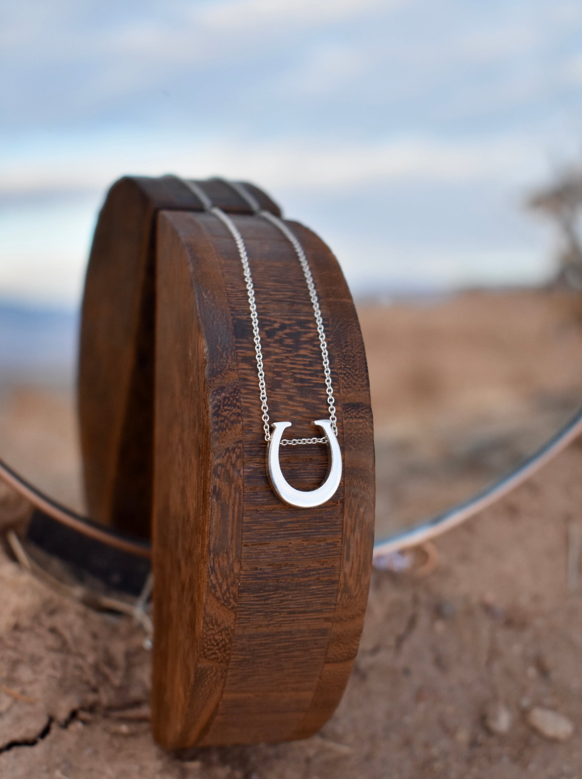 Sterling silver Saddle and Stone Horseshoe necklace pendant with desert in the background