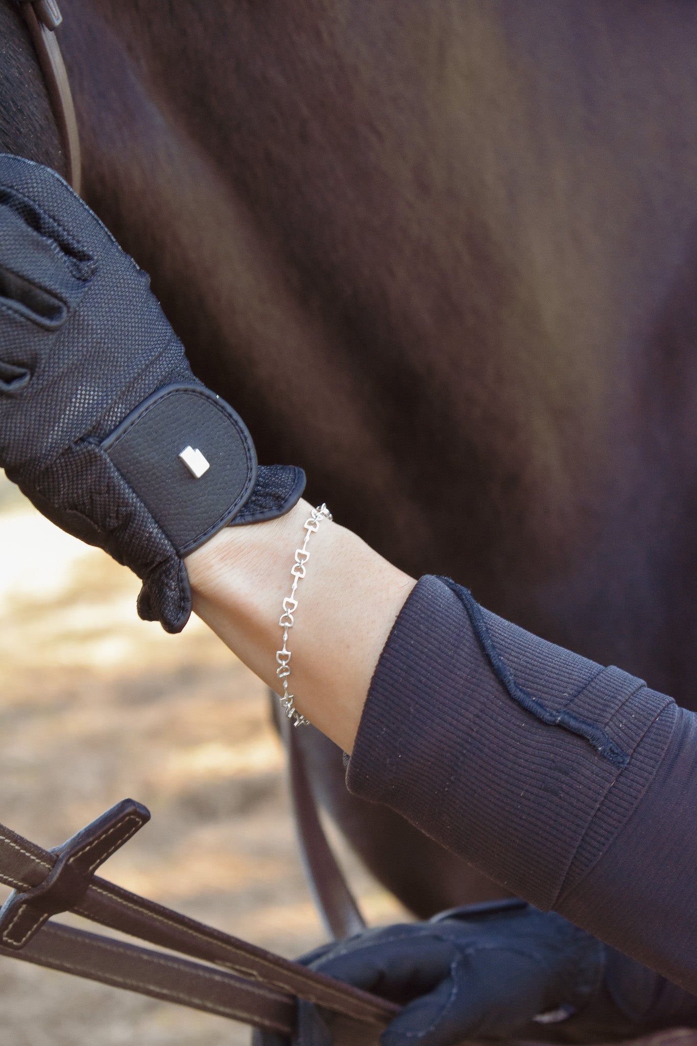 model with riding glove, wearing the sterling silver bit chain bracelet from Saddle & Stone